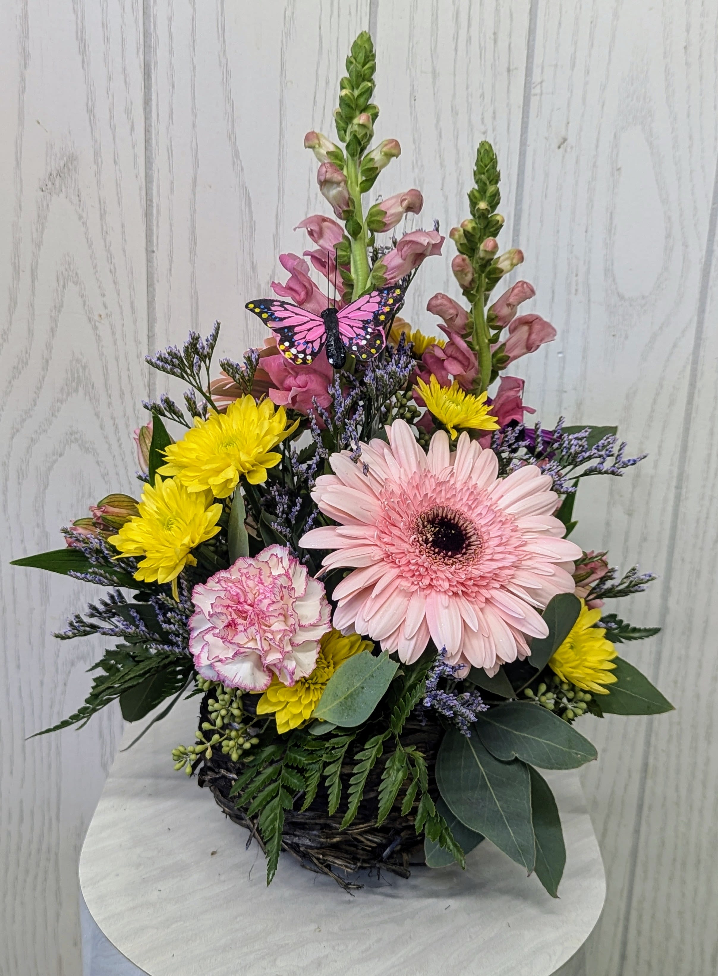 Mixed flower basket with pink gerbera, yellow mums, and snapdragons