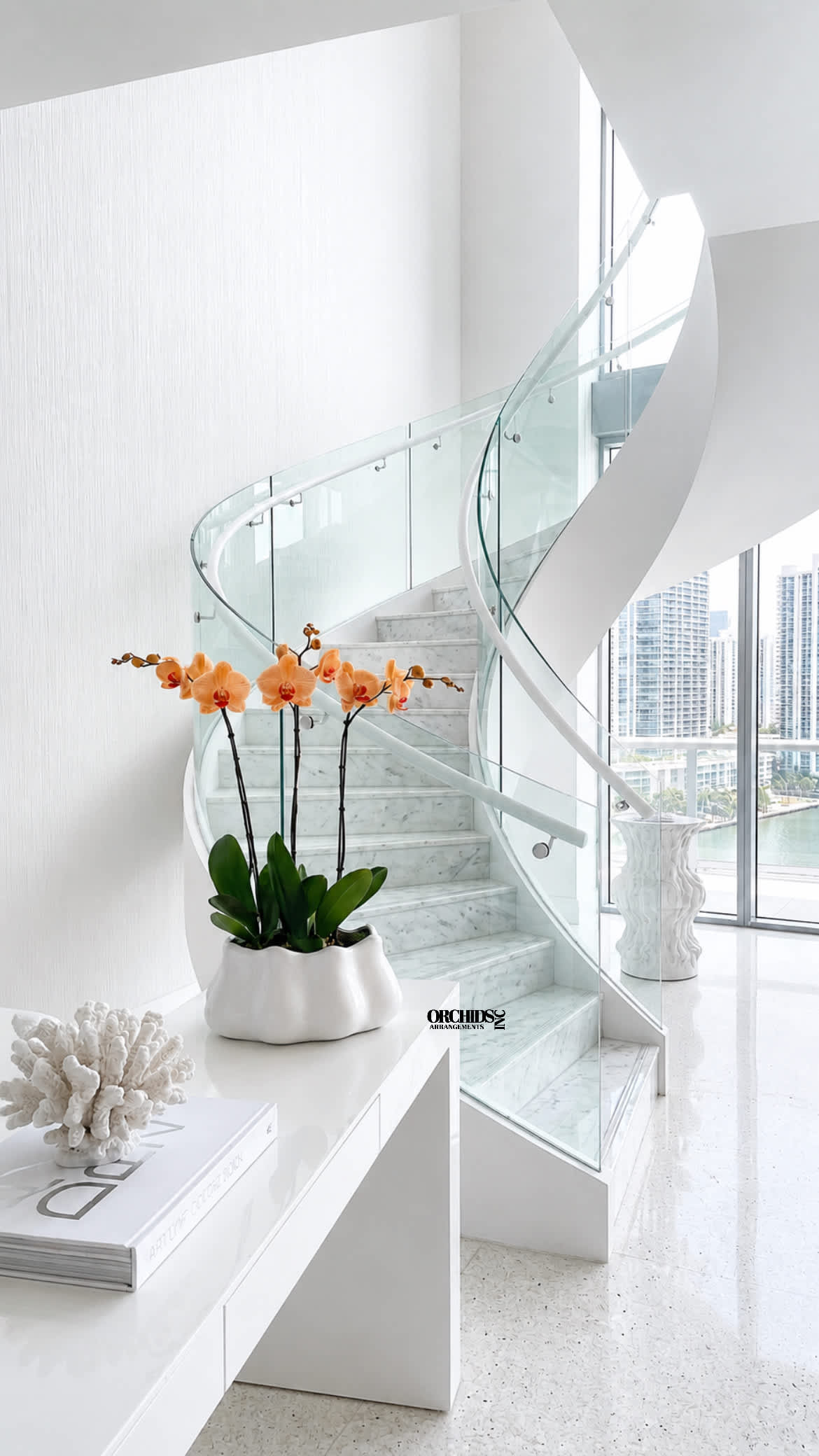 Orange orchids in a white planter on a modern staircase landing.