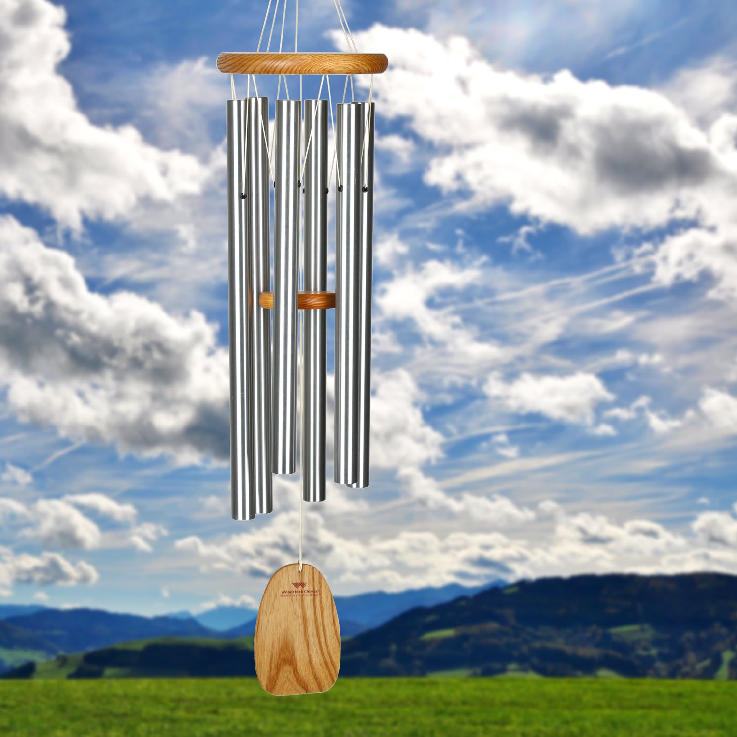 Silver wind chime with wooden accents hanging outdoors