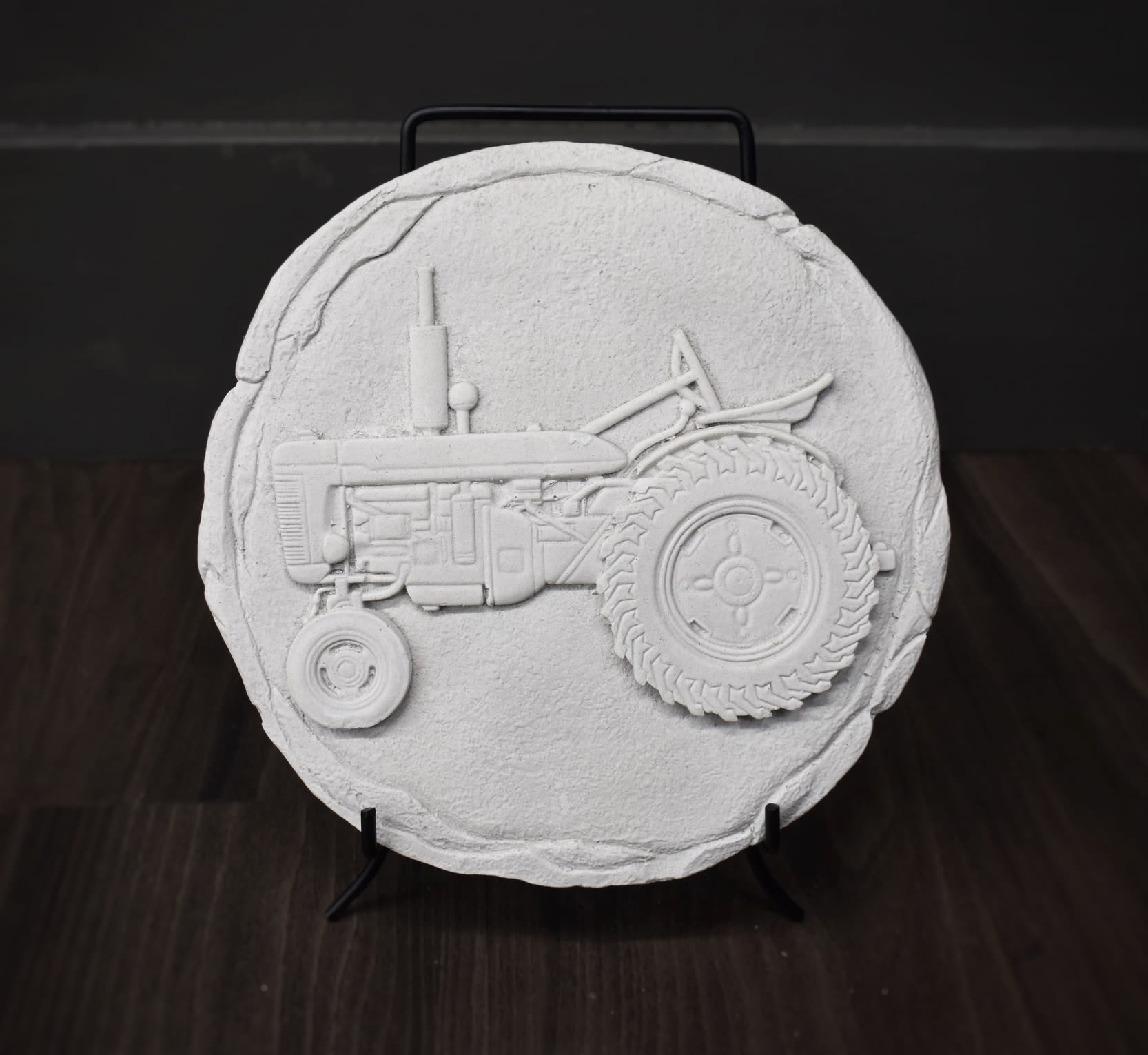 Round white decorative plaque with a raised tractor design