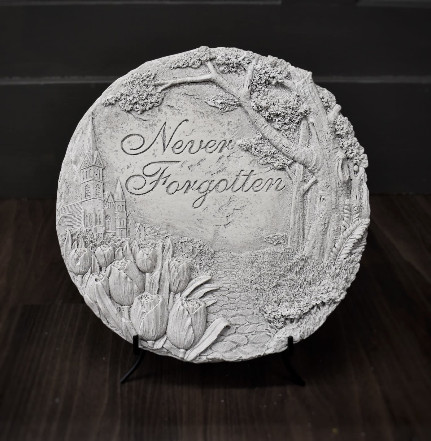 Round decorative plaque with tulips and the words Never Forgotten