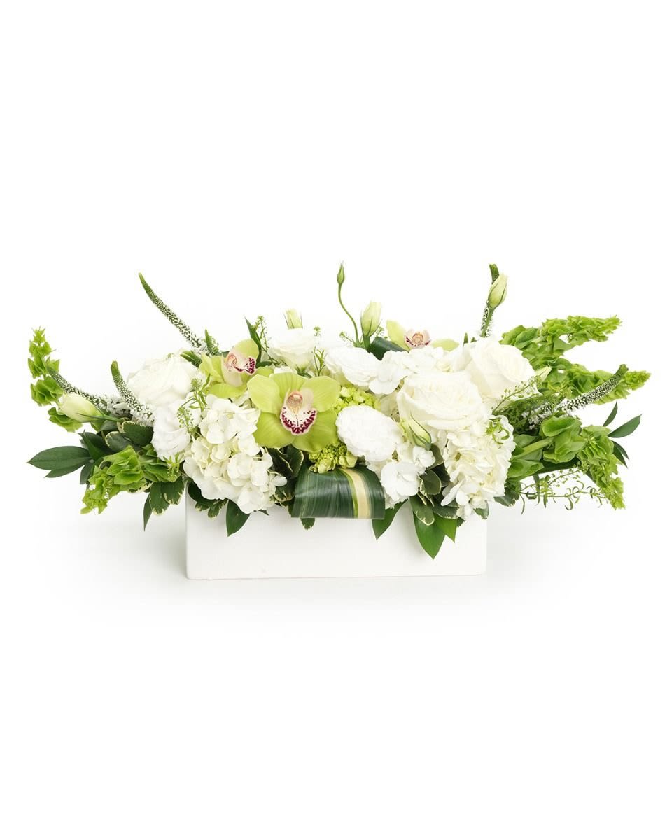 Low white and green floral centerpiece with roses, hydrangeas, and green orchids in a white rectangular container