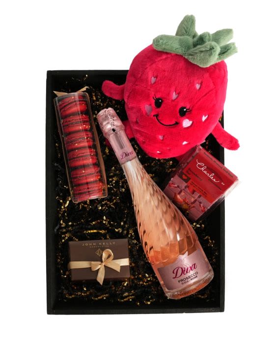 Gift box with strawberry plush, pink sparkling wine, macarons, and chocolates