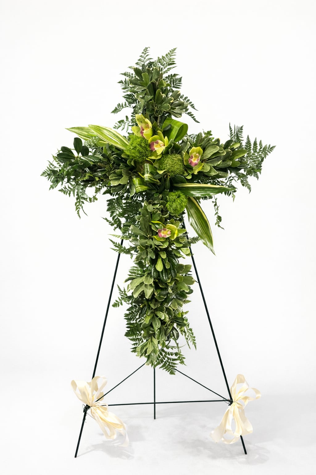 Graceful Green Cross - Funeral cross designed with an abundant selection of fresh greenery and green floral accents, including varieties such as leather leaf, pita, and other seasonal greens, complemented by textured details and green blooms based on availability. A serene, natural, and elegant tribute to honor the memory of a loved one.