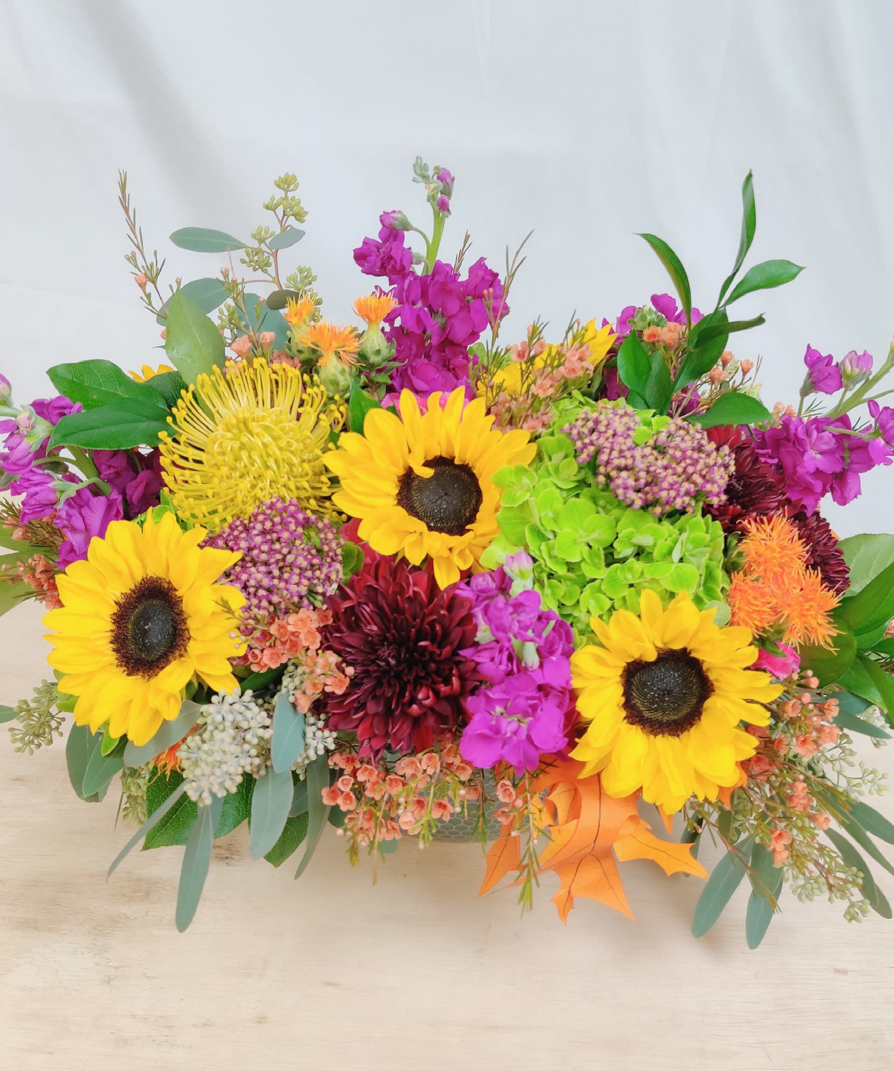 Bright mixed bouquet with sunflowers, magenta blooms, and orange accents