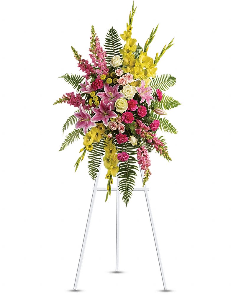 Tall floral standing spray with pink, yellow, and white blooms on an easel