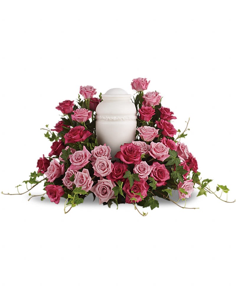 Pink and magenta roses arranged around a white urn