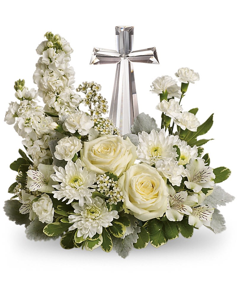 KF_T229-2A  Teleflora's Divine Peace Bouquet - An elegant display of faith and divine peace this beautiful arrangement will comfort the bereaved in a truly thoughtful and respectful way. An exquisite crystal cross is surrounded by a bed of lovely blossoms. It is sure to be appreciated and always remembered. A fragrant mix of pure white blooms - including roses alstroemeria stock carnations and waxflower - is accented with dusty miller and variegated pittosporum around an exclusive Crystal Cross keepsake.Approximately 14 1/2" W x 13 1/2" H