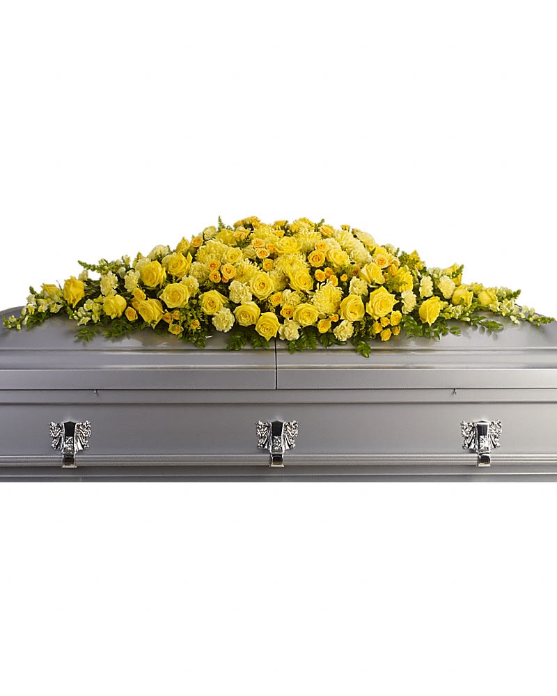 Yellow floral casket spray on a gray casket