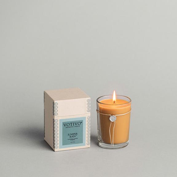 Lit amber candle beside its boxed packaging