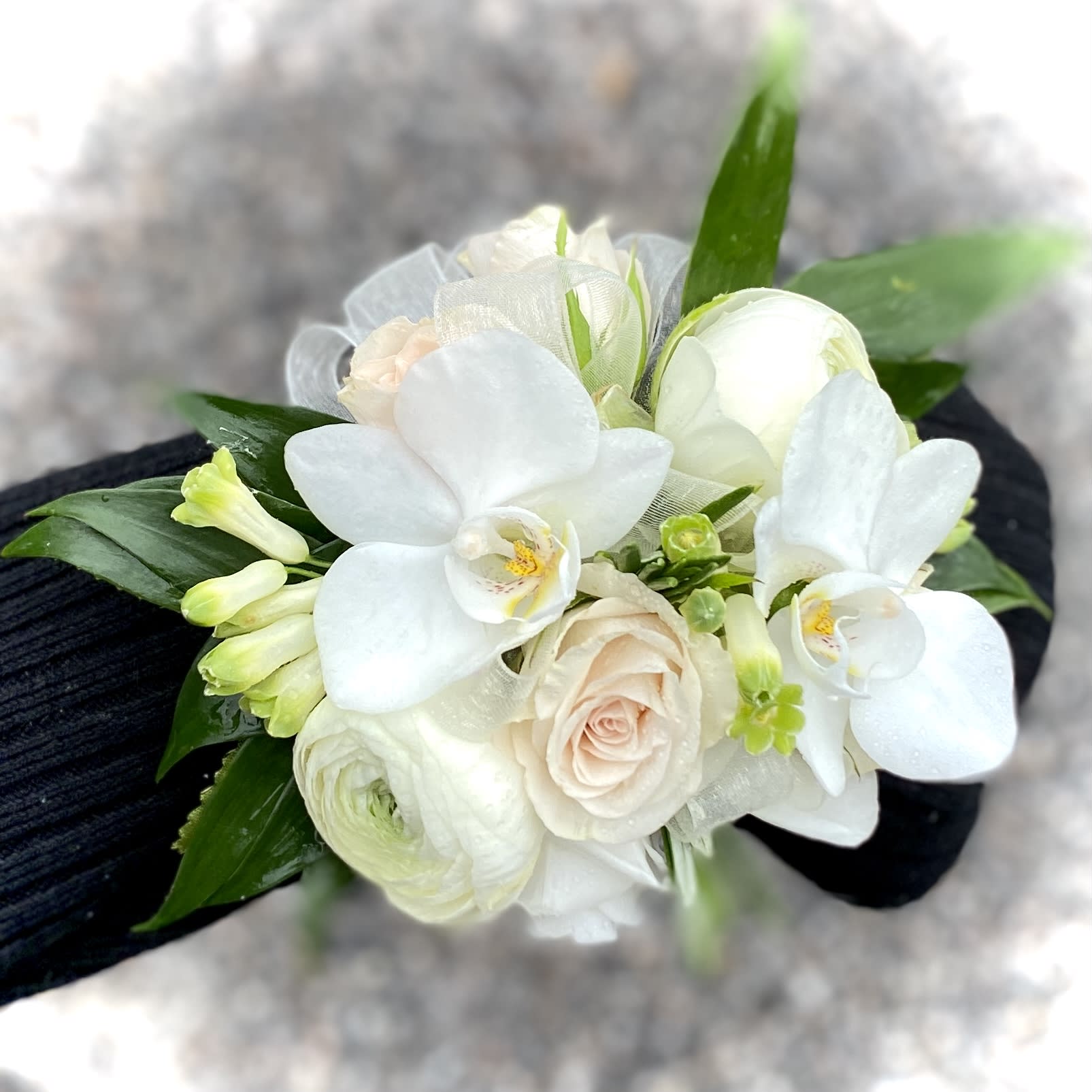 White orchid and rose wrist corsage with green accents