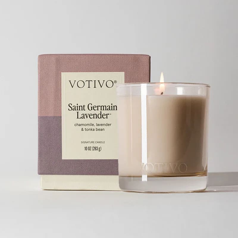 Lit lavender-scented candle in a glass tumbler beside its box