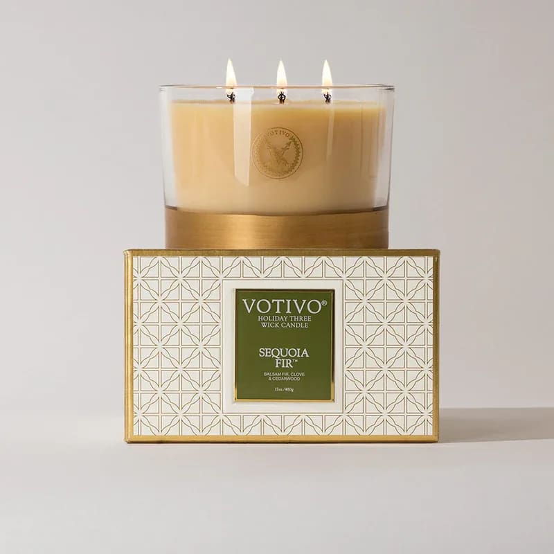 Three-wick candle in a glass jar on a patterned box