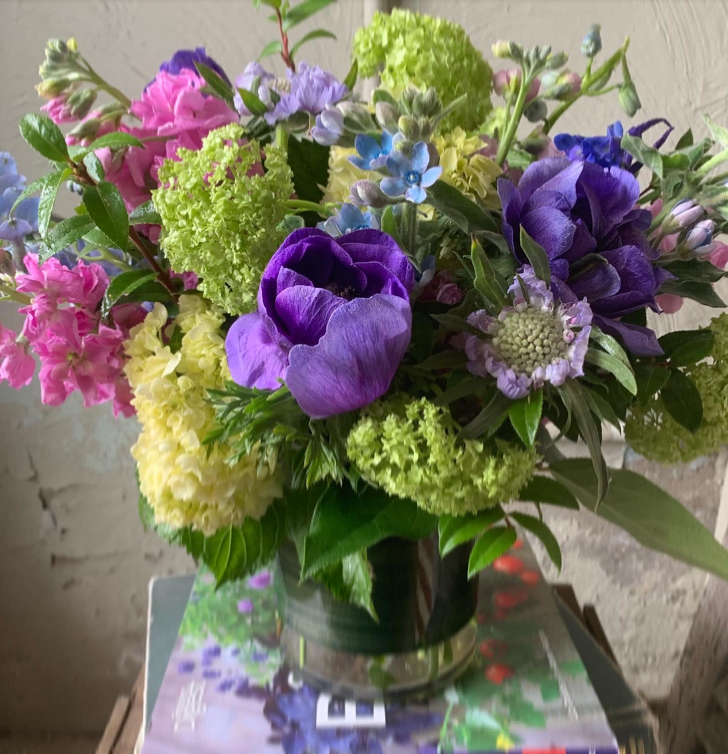 Bouquet of purple, pink, and green flowers in a glass vase
