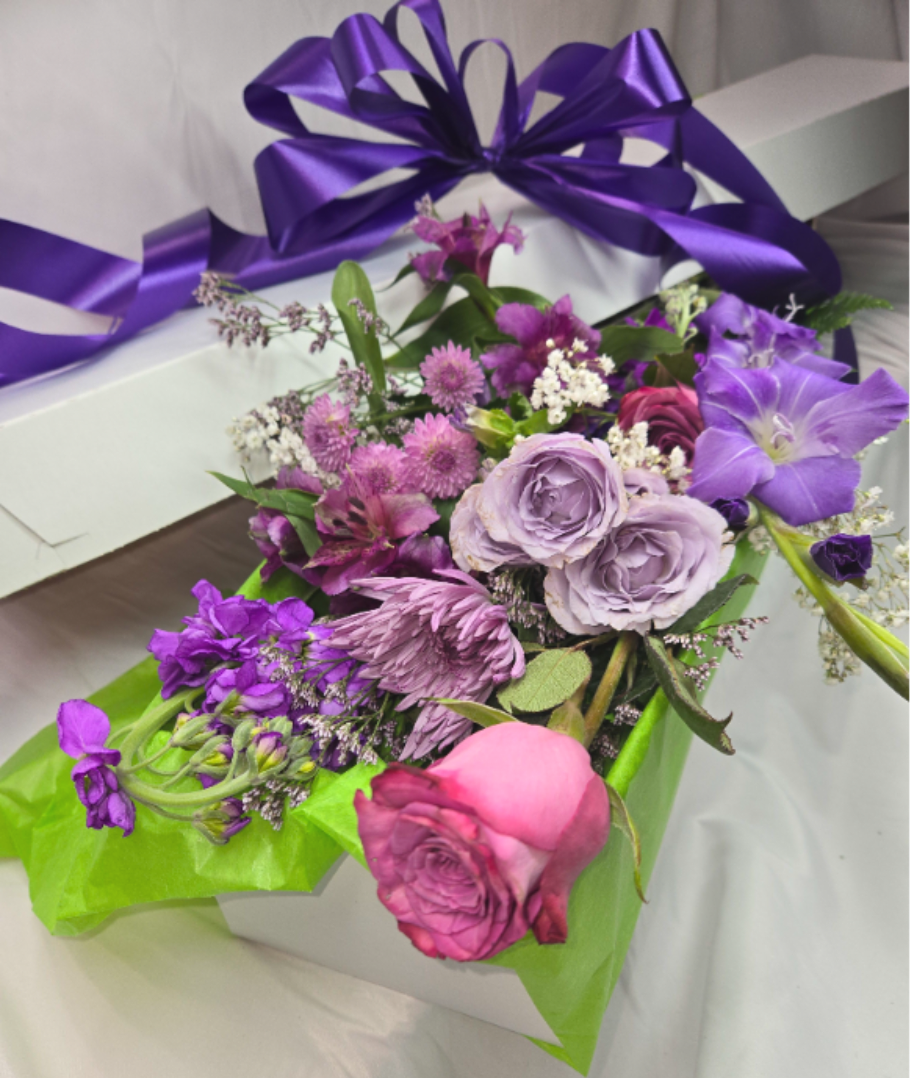 The Purple Box - If you want to bring joy to someone, just send a bouquet of the loveliest flowers around! We will curate the freshest seasonal blooms in stunning shades of purples and lavender! Each hand designed grouping will be unique. The pictured flowers are an example of the lovely blossoms we incorporate into a lavish boxed presentation with a coordinating ribbon. PLEASE NOTE, no vase is included.