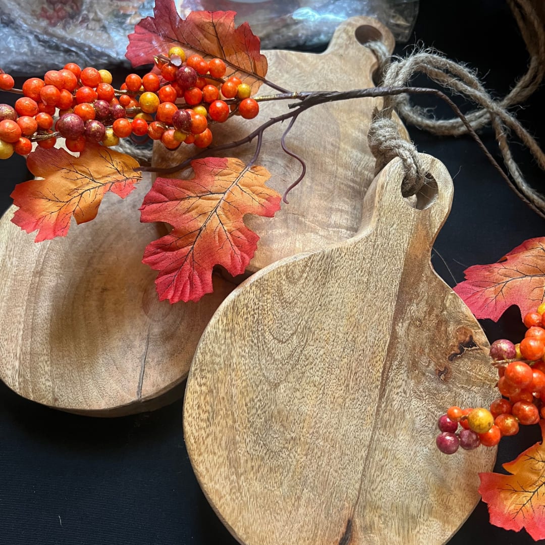 Wooden pumpkin-shaped trays with autumn berry and leaf decorations