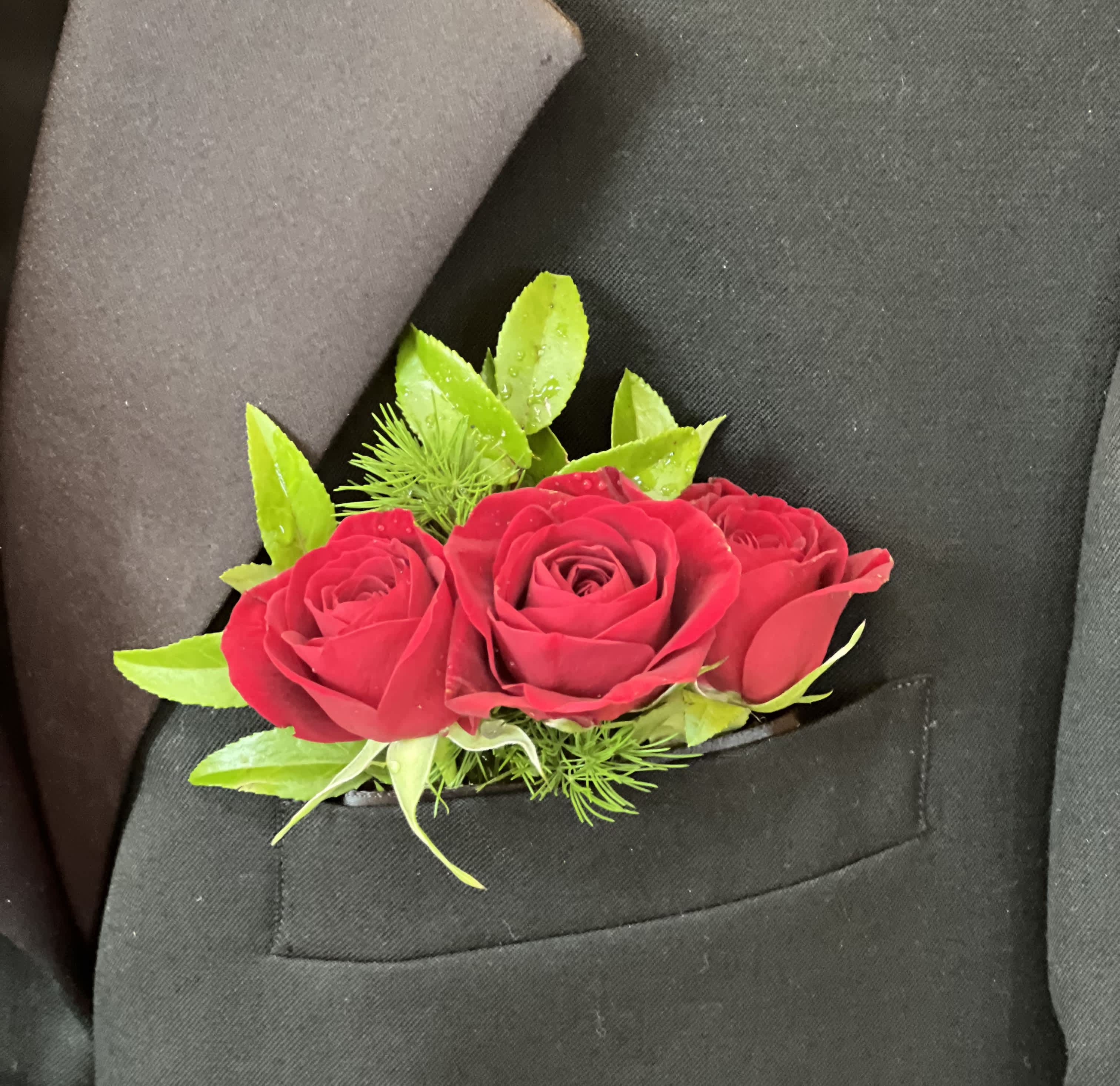 Red rose boutonniere pinned to a black suit jacket