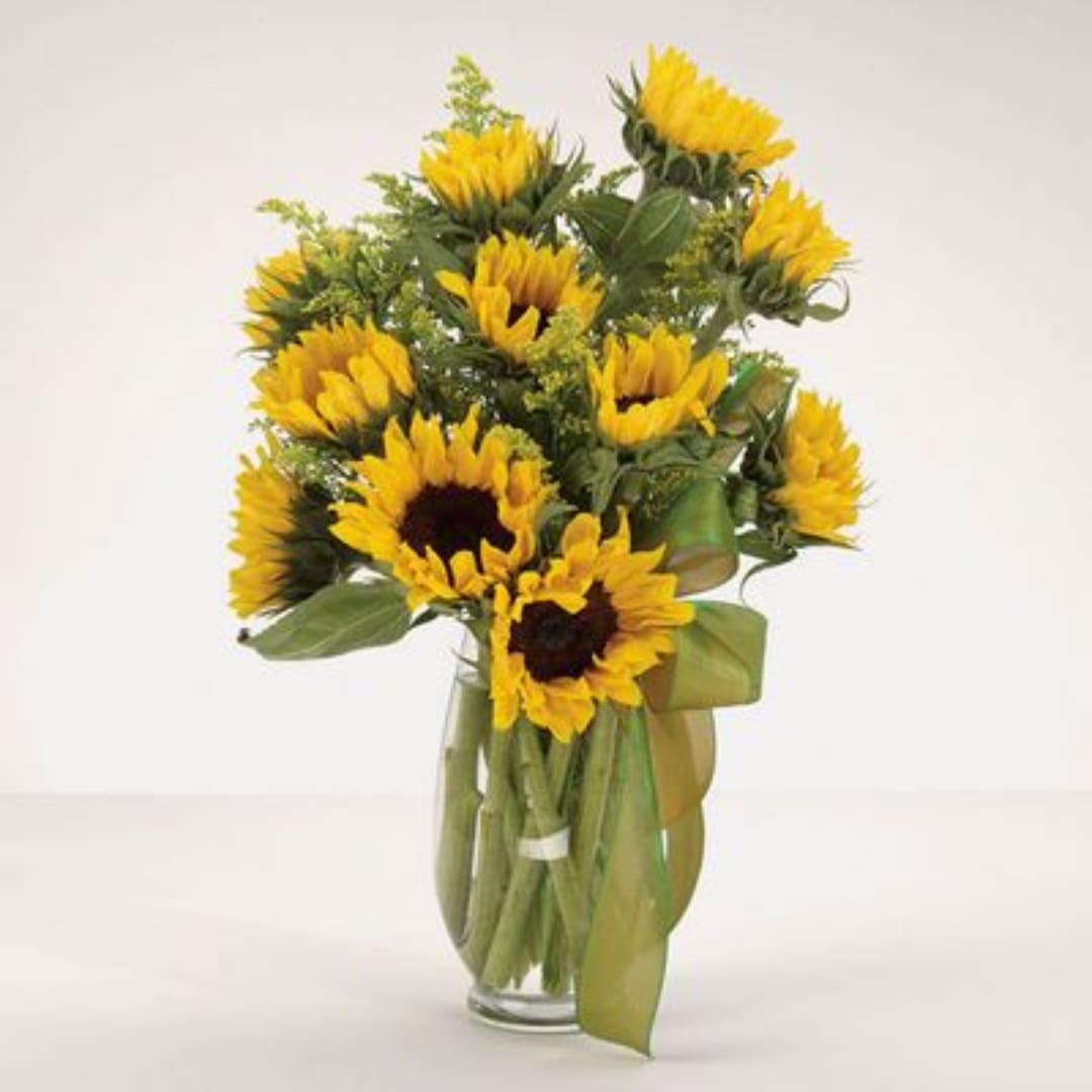 Bouquet of yellow sunflowers in a clear glass vase
