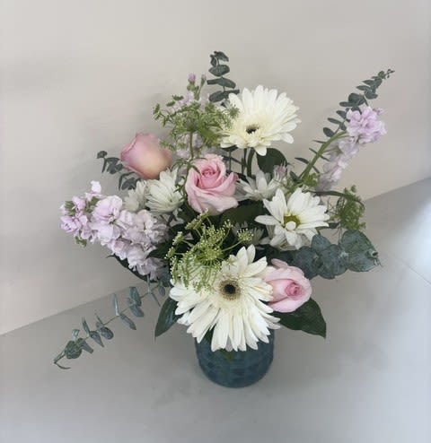 Cloud Nine Blooms - Cloud Nine Blooms is a dreamy arrangement featuring soft pastel hues in a charming blue vase. Delicate light pink roses and stock are paired with crisp white gerbera daisies and daisies, creating a fresh, airy design that brings beauty, joy, and elegance to any occasion.