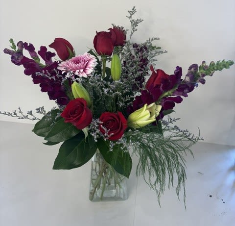 Garden of Devotion - Garden of Devotion is a romantic garden-inspired arrangement featuring rich red roses, elegant white lilies, soft pink gerbera daisies, and deep burgundy snapdragons. This lush blend of color and texture creates a heartfelt expression of love and admiration, perfect for meaningful occasions and unforgettable gestures.