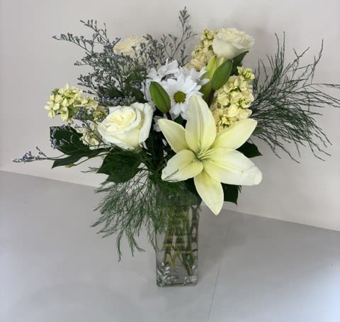 Wings of Hope - A serene expression of love and remembrance, Wings of Hope is a graceful sympathy arrangement designed to offer comfort during times of loss. Featuring elegant white roses, lilies, stock, and daisies, this arrangement symbolizes purity, peace, and enduring memory. Presented in a keepsake vase inscribed with a heartfelt message: In Loving Memory Those we love don't go away they walk beside us every day unseen, unheard, but always near, still loved, still missing and very dear.  It serves as a lasting tribute to those who remain forever in our hearts. Thoughtfully arranged in soft, calming tones, Wings of Hope offers a gentle reminder that love never fades and memories live on.