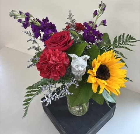 Pawprints in Heaven – Cat - Pawprints in Heaven – Cat is a heartfelt tribute created to honor the love, comfort, and cherished memories of a beloved feline companion. Designed with pet-safe flowers including cheerful sunflowers, fragrant stock, classic roses, and carnations, this thoughtful arrangement offers comfort and remembrance during a difficult time.  Accented with a touching cat angel pick, this meaningful tribute is a gentle reminder that although our treasured companions are no longer by our side, the pawprints they leave on our hearts remain forever. A beautiful expression of sympathy to celebrate a lifetime of love, companionship, and treasured memories.