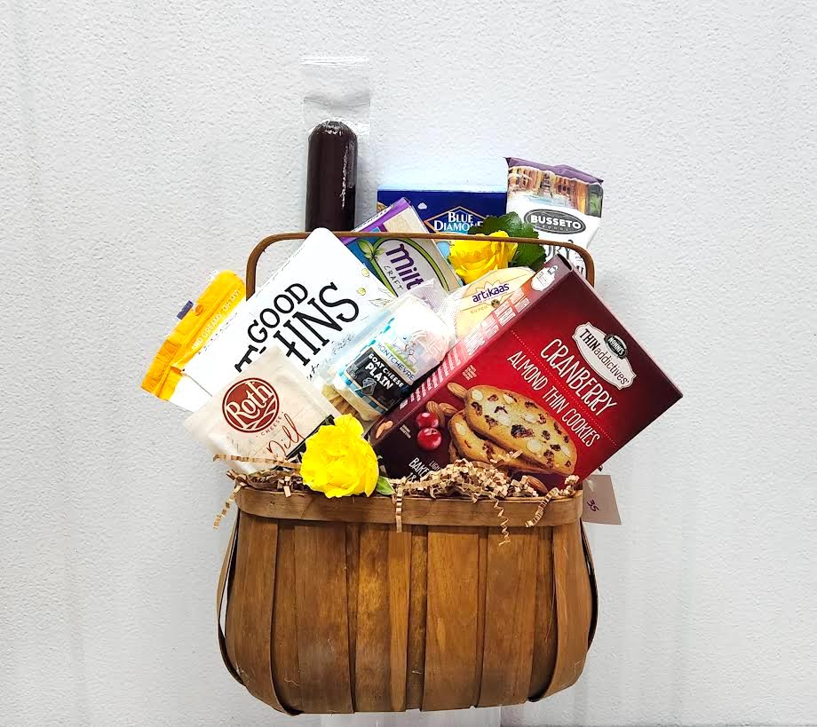 Gift basket with assorted snacks and two yellow flowers