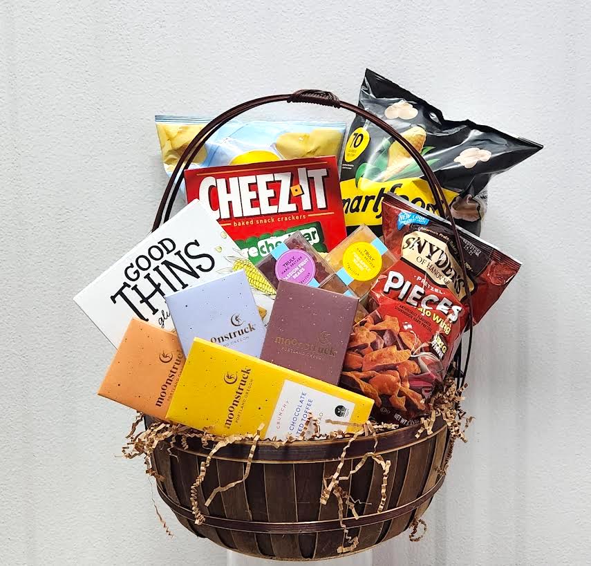 Gift basket with assorted snacks and chocolate bars in a wooden basket