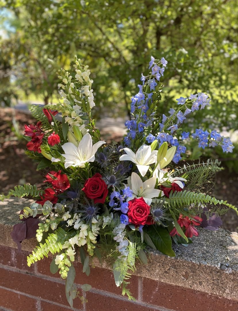 Mixed bouquet with red roses, white lilies, and blue delphinium