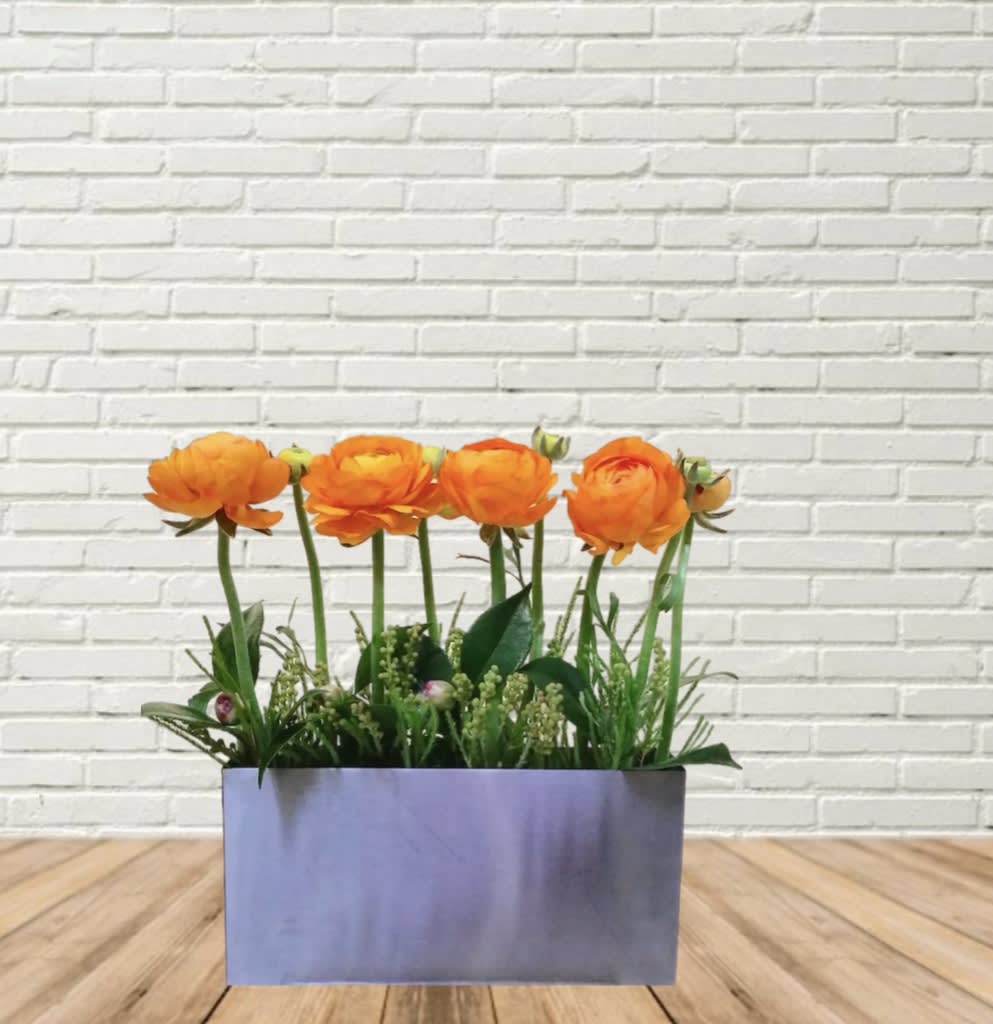Orange flowers arranged in a rectangular silver container