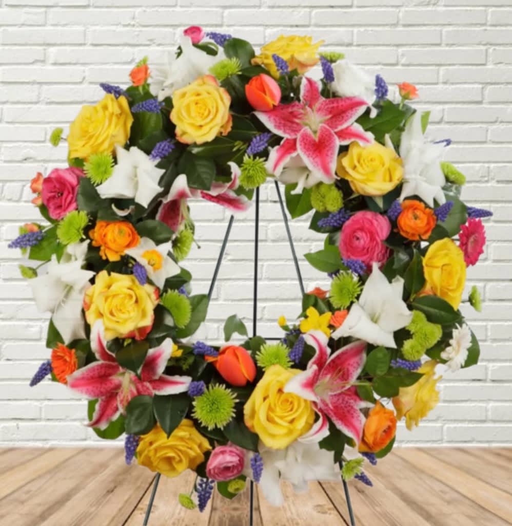Colorful floral wreath with roses and lilies on a metal stand