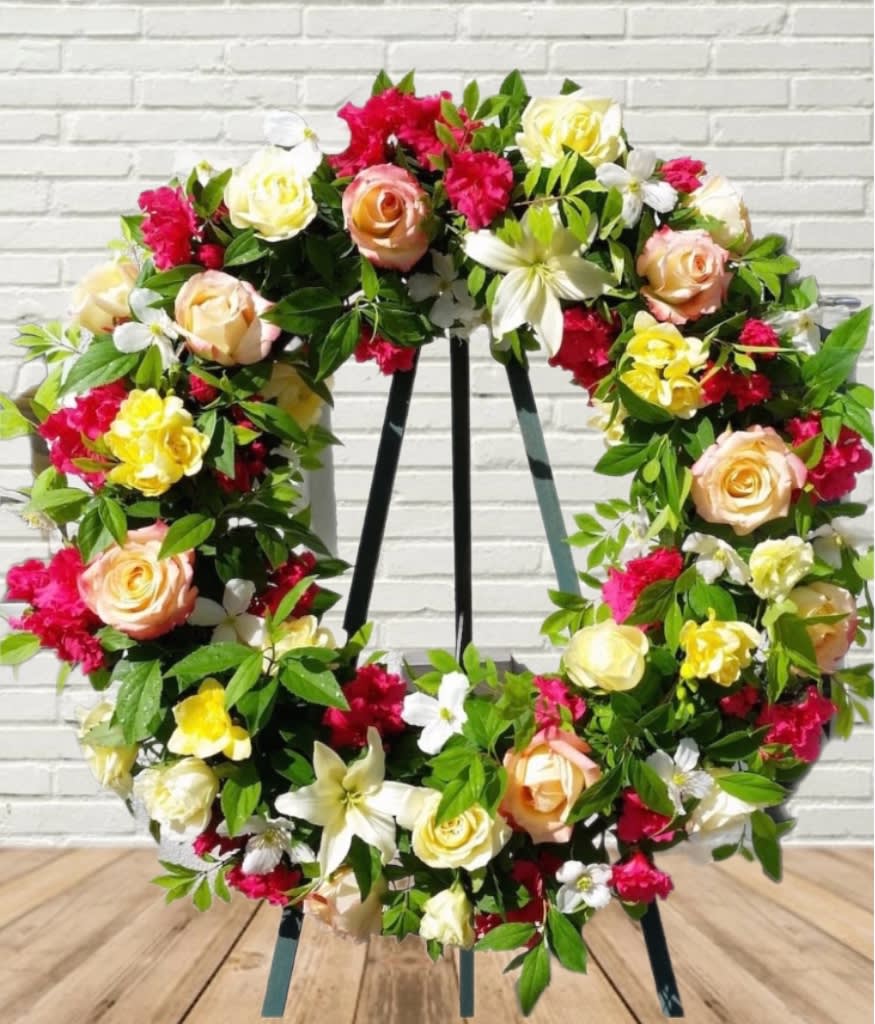 Floral wreath with roses and mixed blooms on a stand