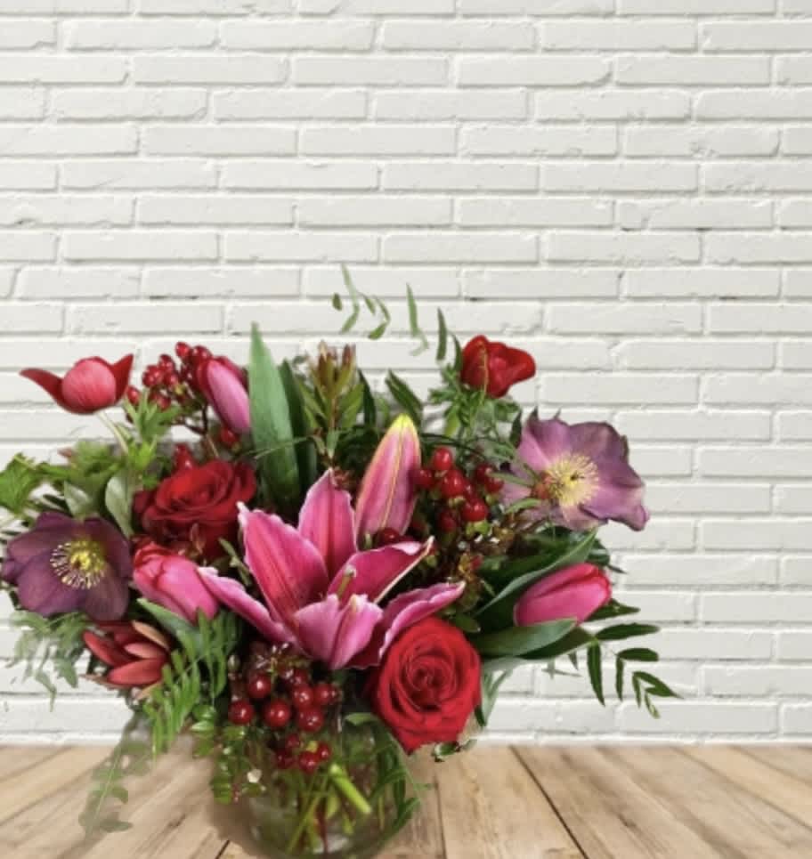 Bouquet of pink lilies and red roses in a glass vase