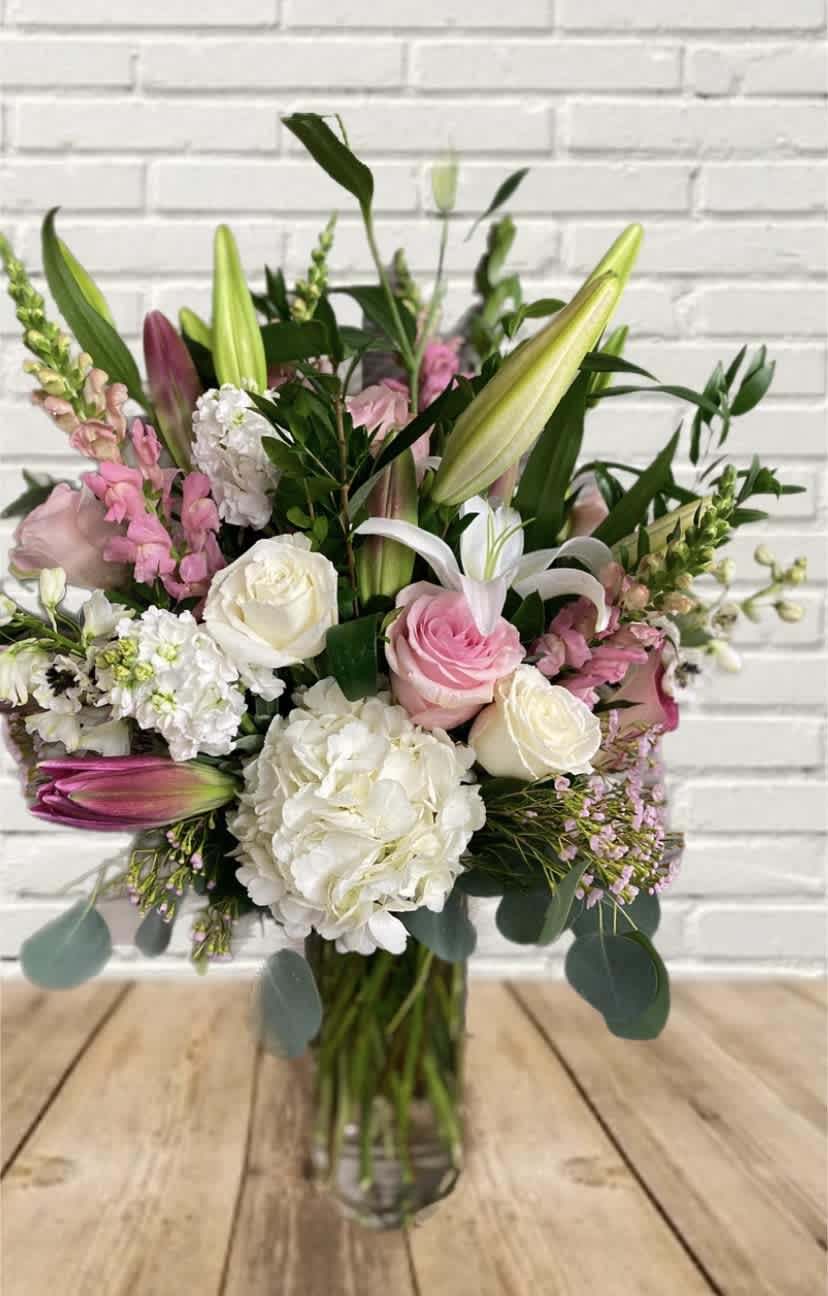 Pink and white bouquet with lilies and roses in a glass vase