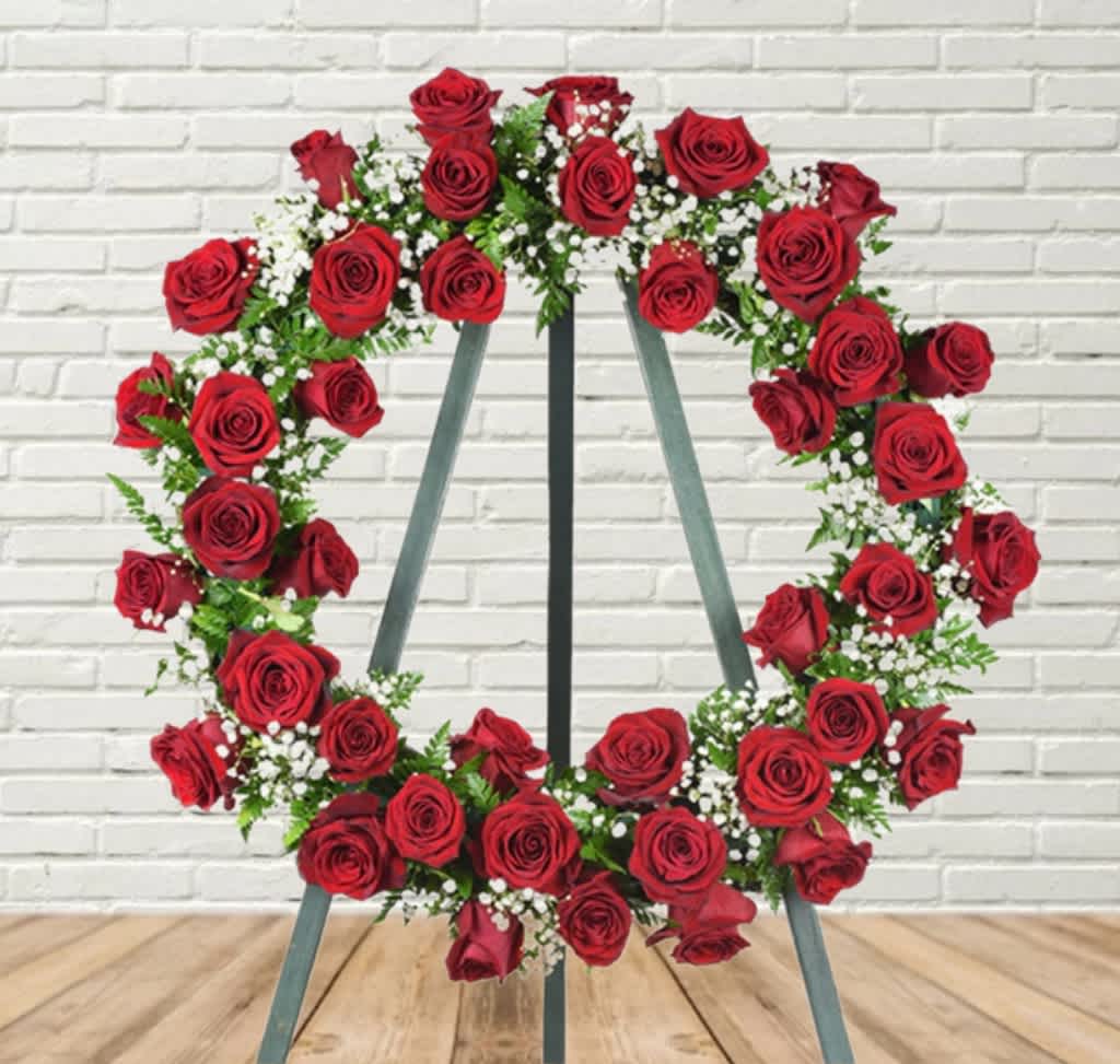 Heart-shaped wreath of red roses on a metal stand