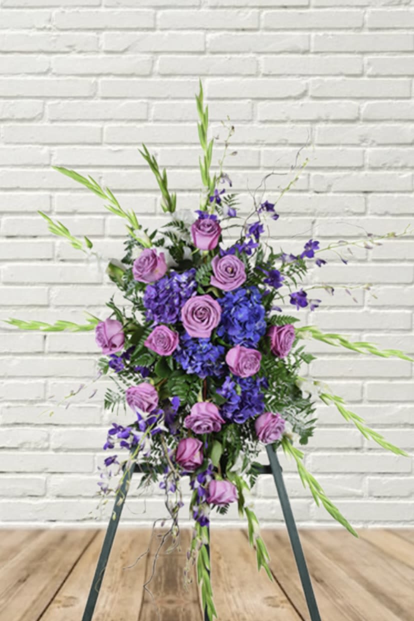 Tall purple and lavender floral arrangement with roses and blue blooms