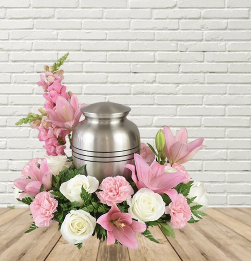 Pink and white floral arrangement around a silver urn
