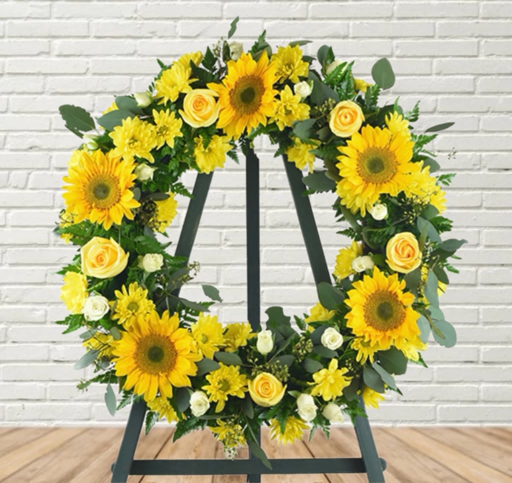 Yellow floral wreath on a black easel stand
