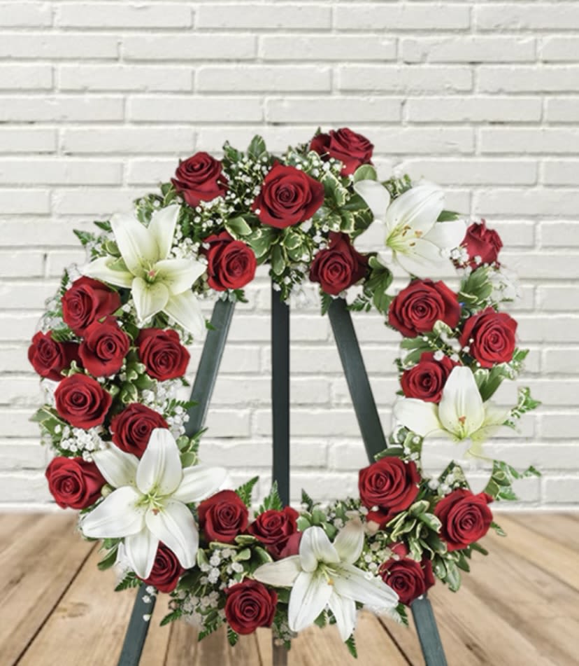 Red rose and white lily wreath on a stand