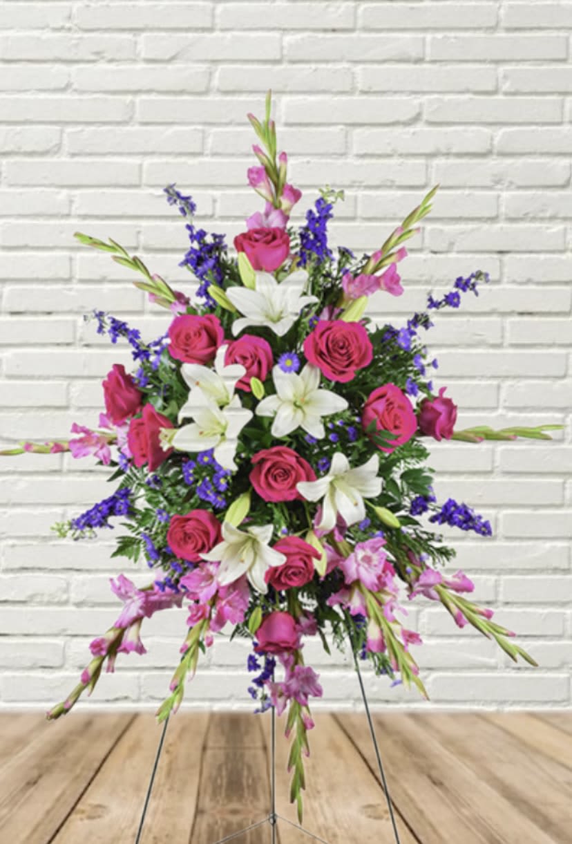 Standing floral spray with pink roses, white lilies, and purple accents