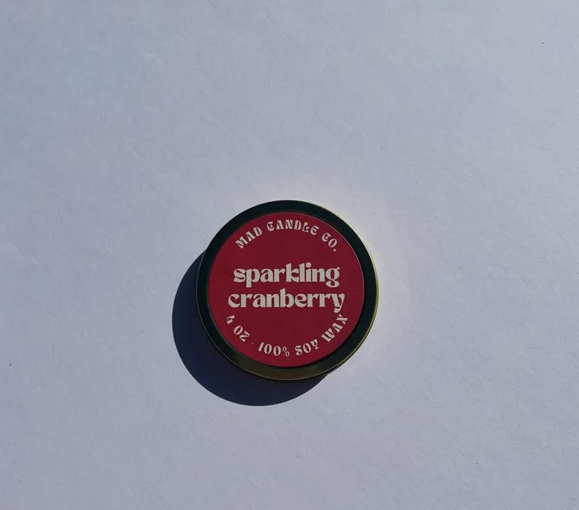 Round tin candle labeled sparkling cranberry