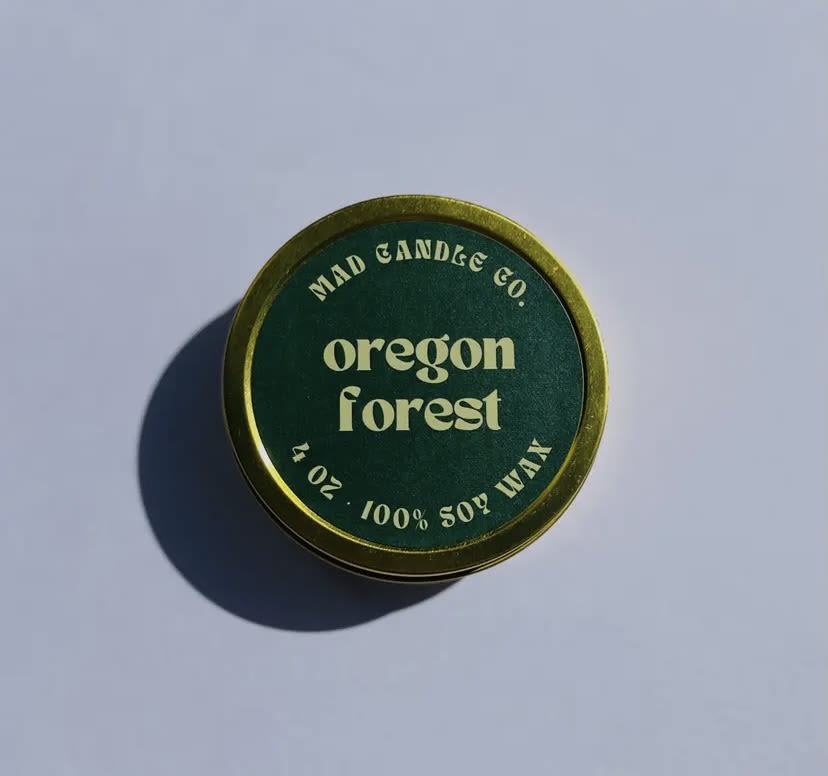 Round green candle tin labeled Oregon Forest
