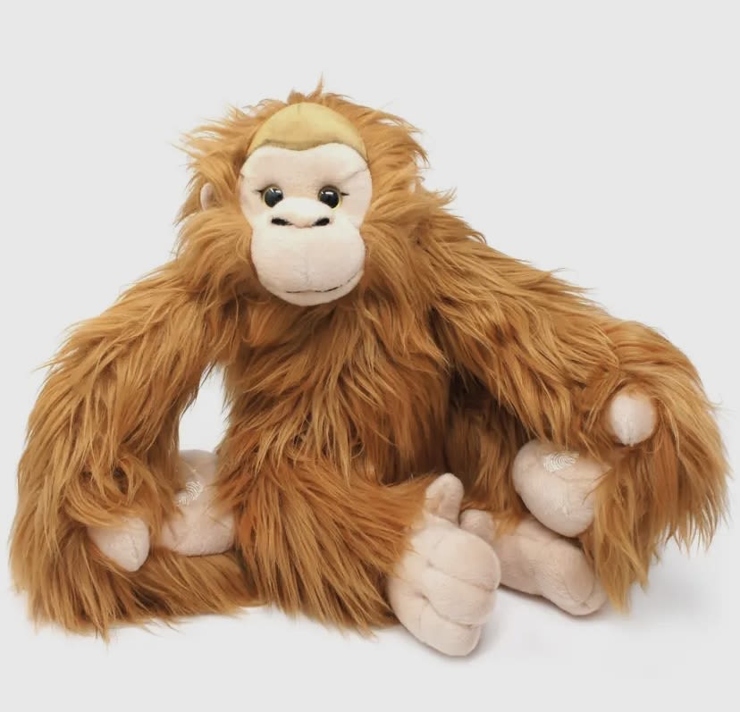 Plush orangutan toy sitting on a white background