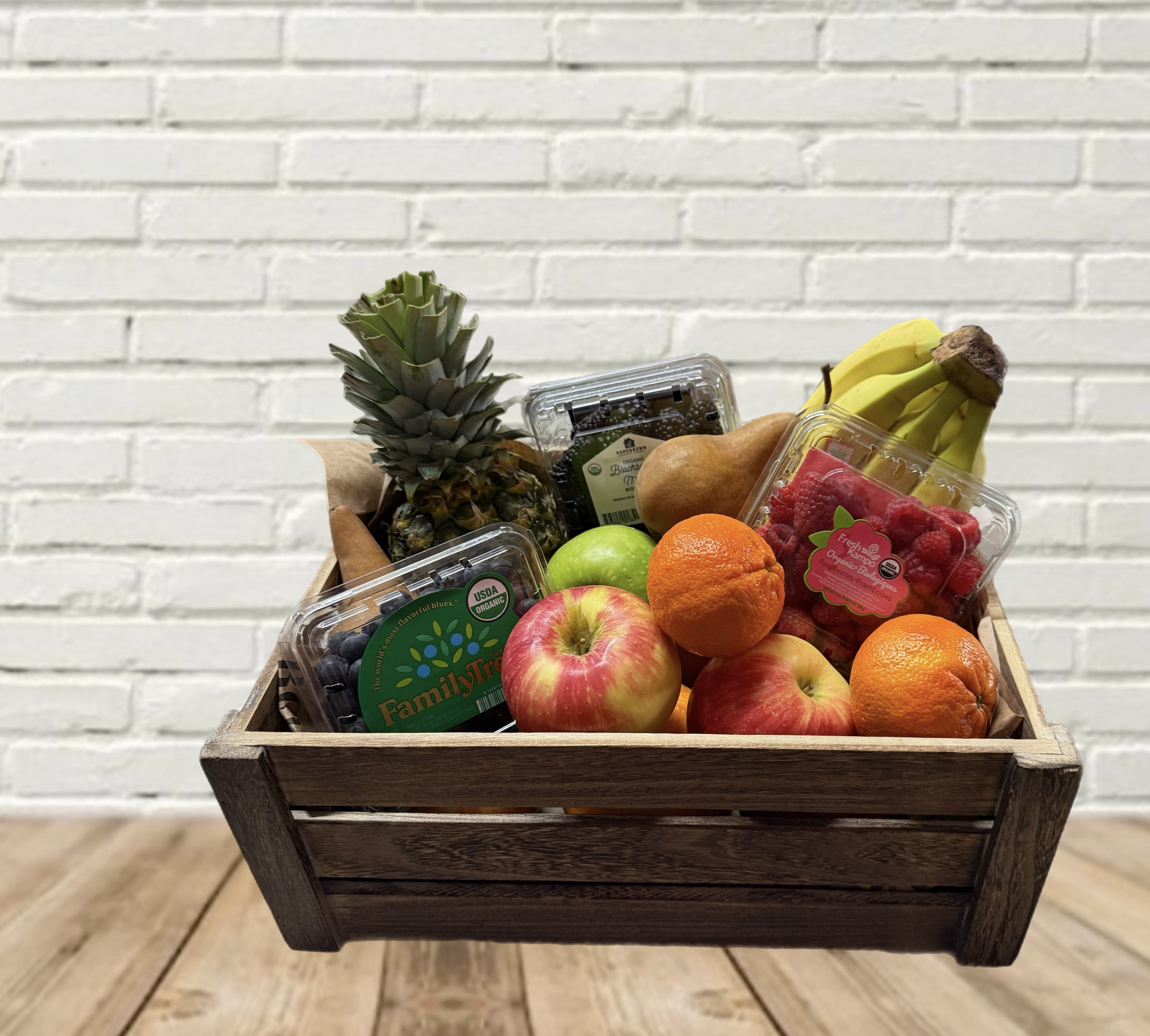 Wooden crate filled with assorted fruit and berry containers