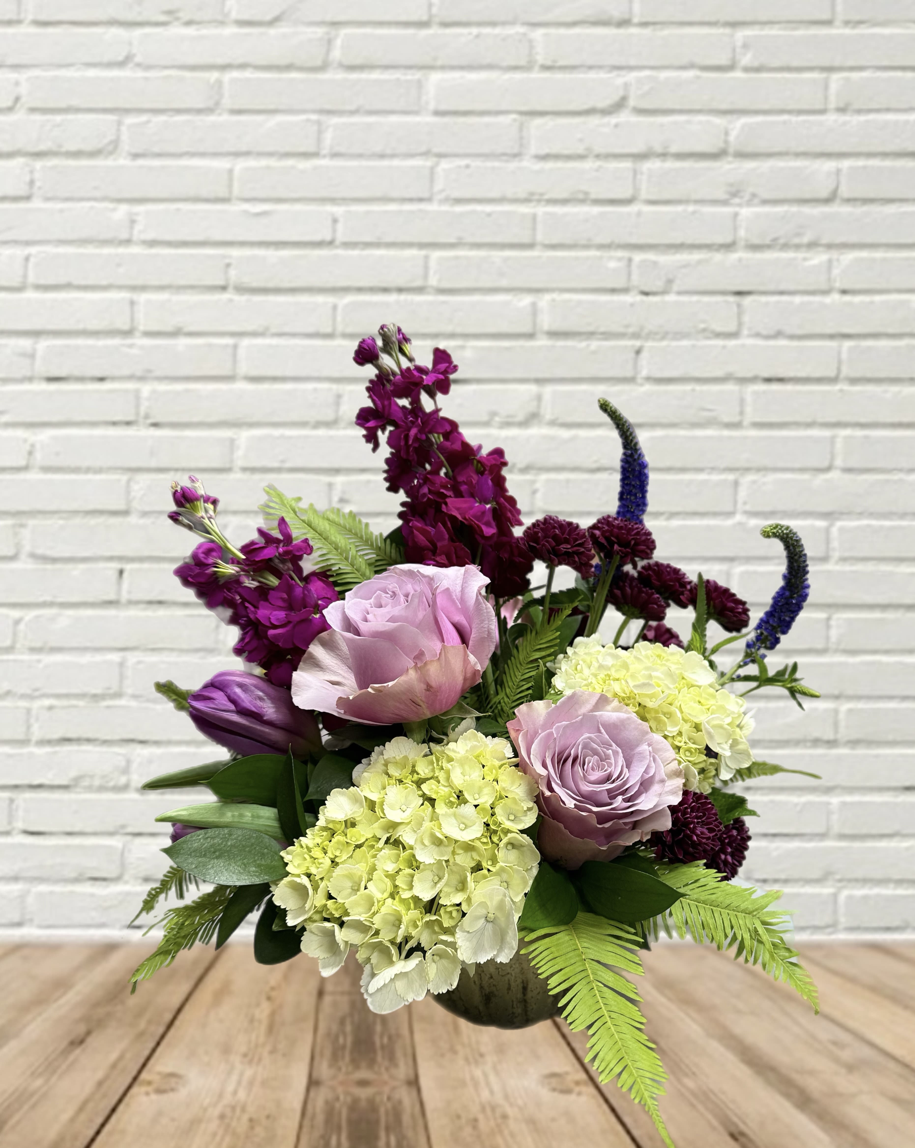 Mixed bouquet with lavender roses, hydrangeas, and purple blooms in a vase