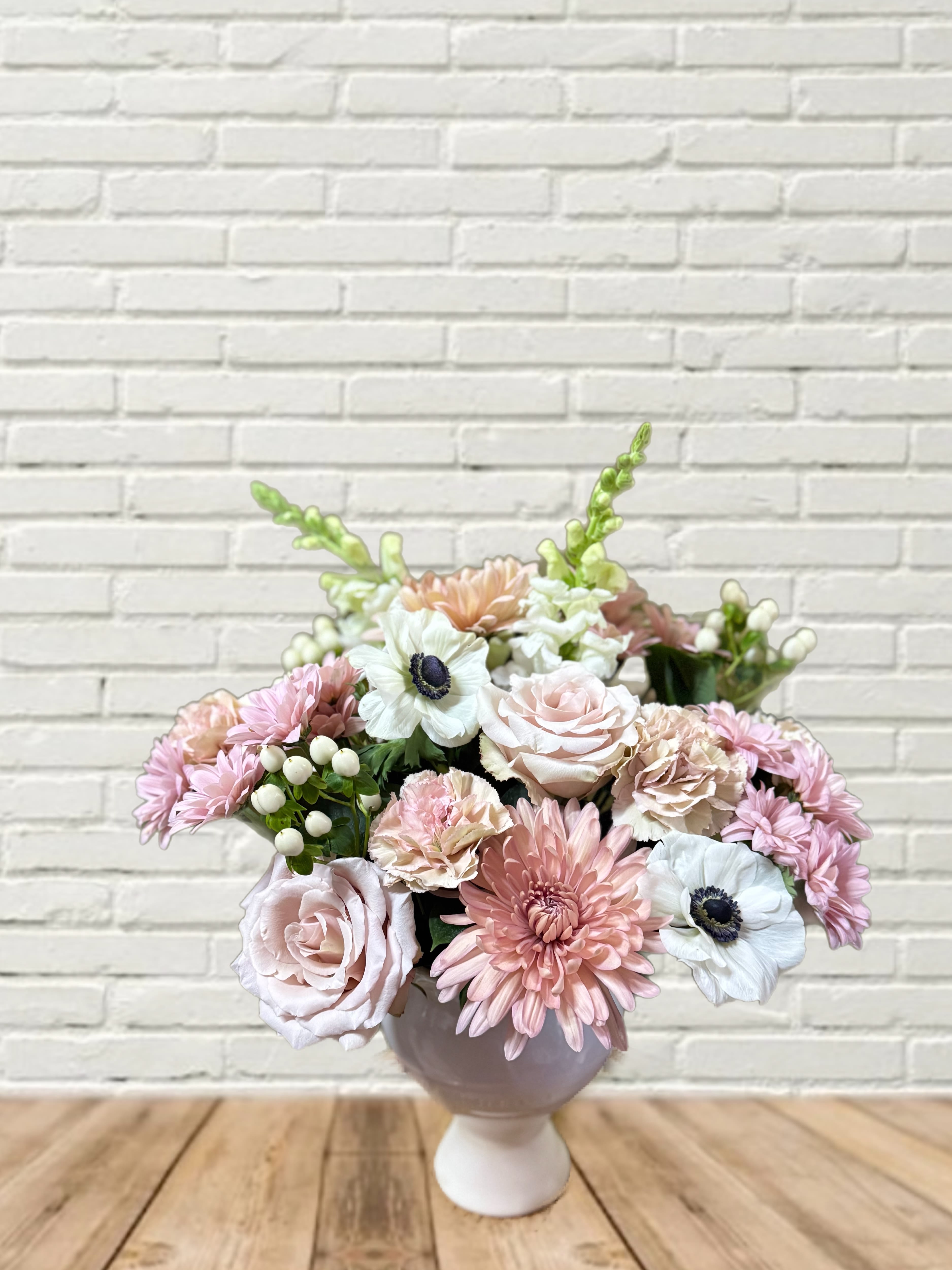 Pink and white flower arrangement in a round vase