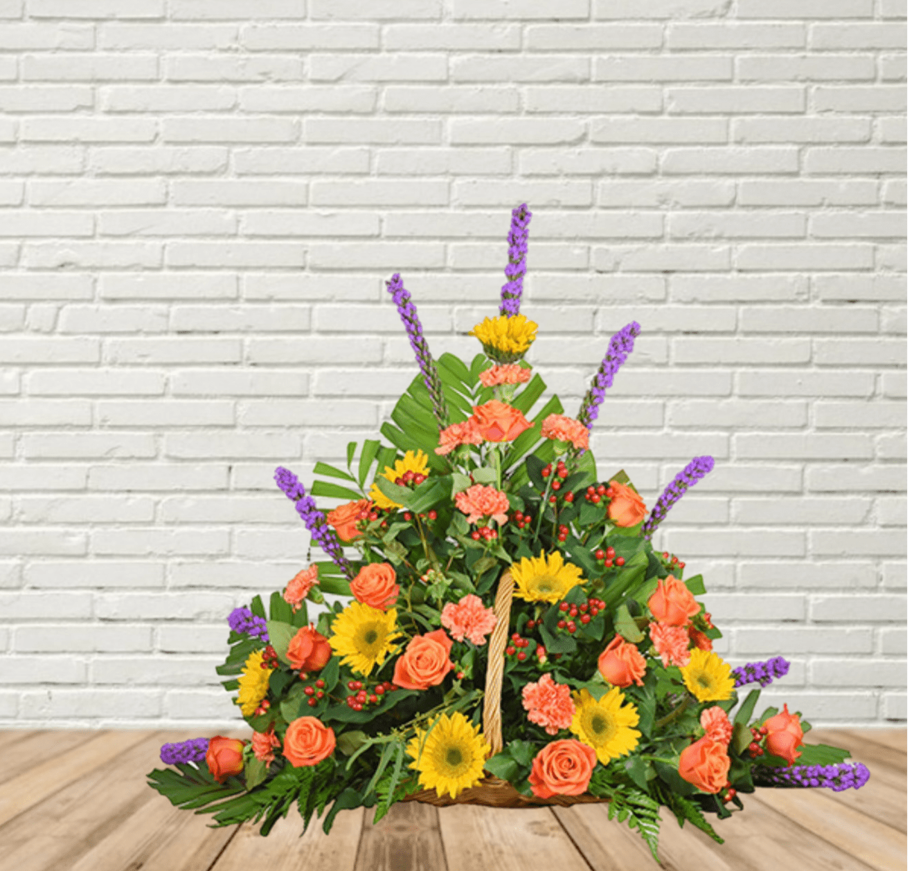 Basket arrangement of orange roses, yellow daisies, and purple spikes