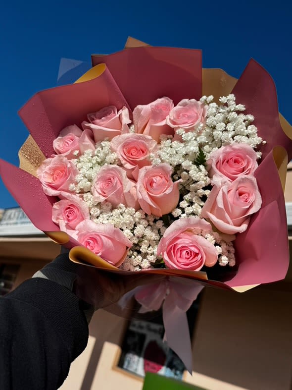Blush Charm - Soft pink roses aired with dainty white baby's breath, nestled in elegant pink and gold wrapping for a romantic and tender presentation. 