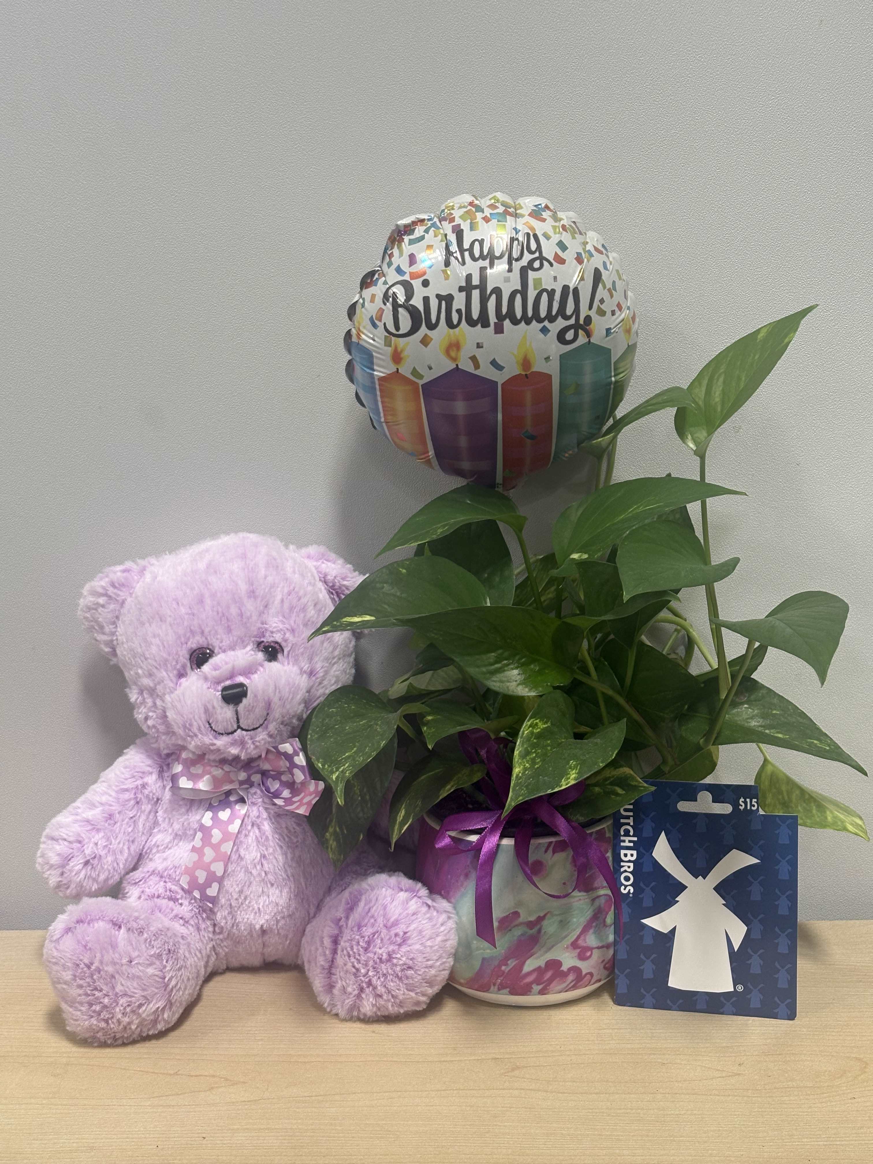Potted green plant with a birthday balloon, teddy bear, and gift card