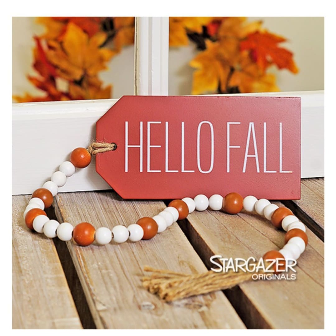 Fall-themed tag with beaded garland on a wooden surface
